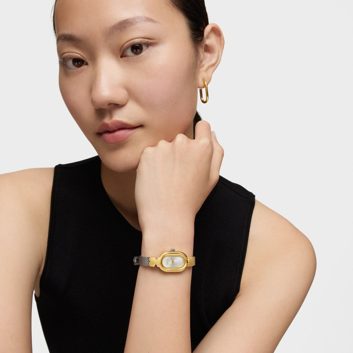 Woman wearing TOUS WATCHES Mod. 3000145300 with gold face and black strap.