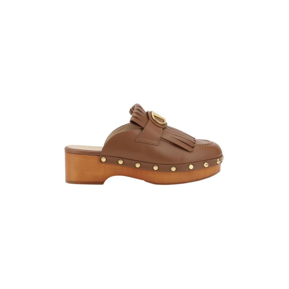 Valentino Garavani Leather MulesValentino Garavani’s leather sabot is an elegant reinterpretation of the clog, perfect for those seeking a mix of comfort and style. The model features a round toe that ensures a comfortable fit, while the iconic three-dime