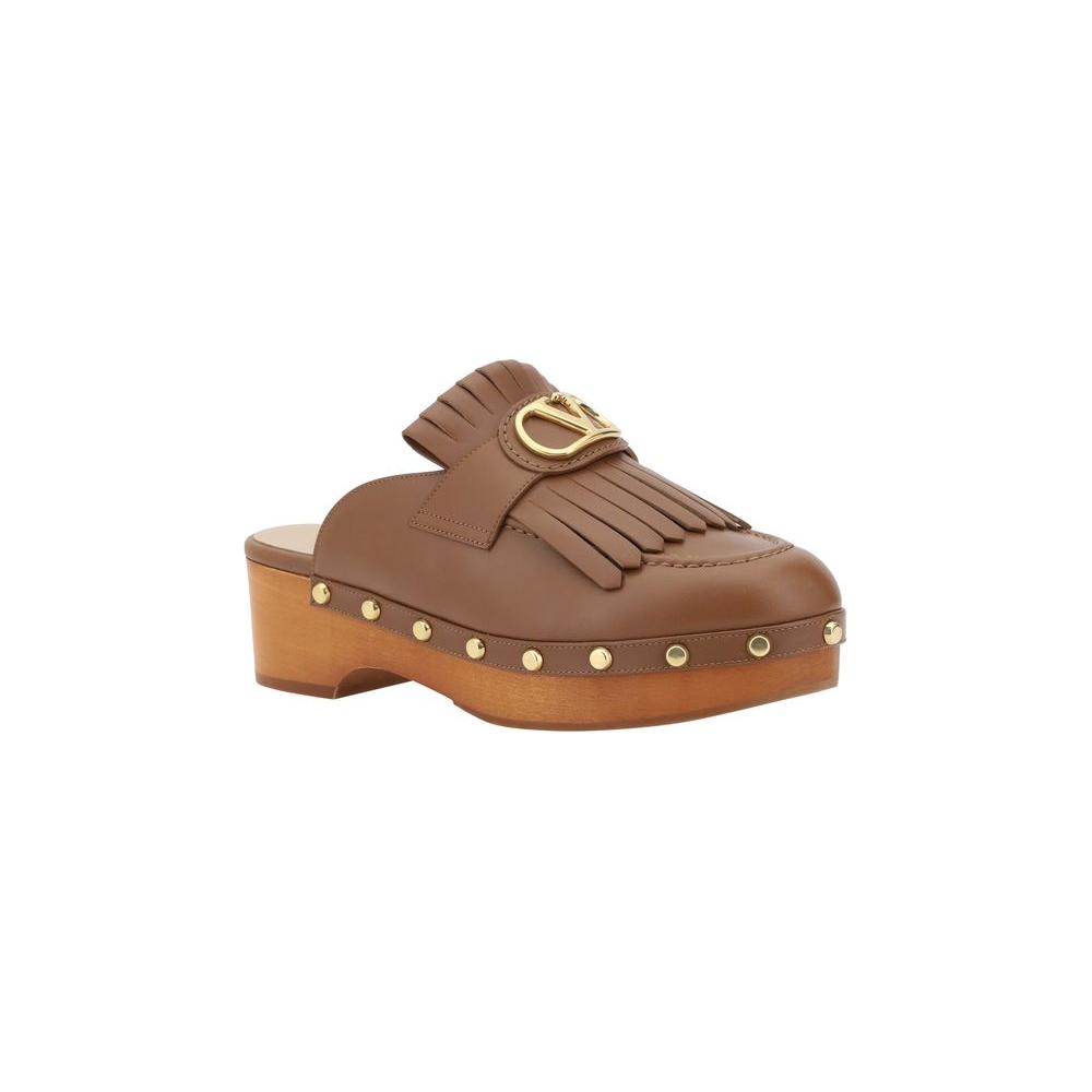 Valentino Garavani Leather MulesValentino Garavani’s leather sabot is an elegant reinterpretation of the clog, perfect for those seeking a mix of comfort and style. The model features a round toe that ensures a comfortable fit, while the iconic three-dime