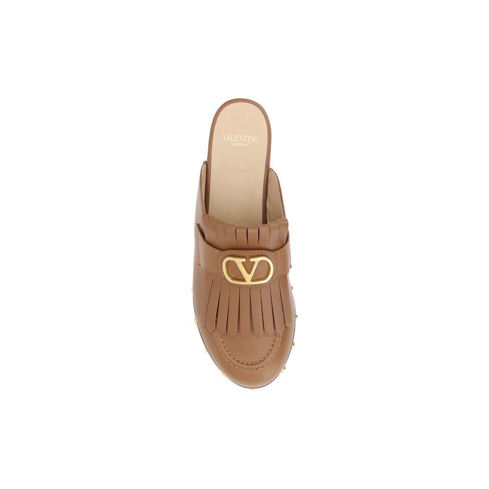 Valentino Garavani Leather MulesValentino Garavani’s leather sabot is an elegant reinterpretation of the clog, perfect for those seeking a mix of comfort and style. The model features a round toe that ensures a comfortable fit, while the iconic three-dime