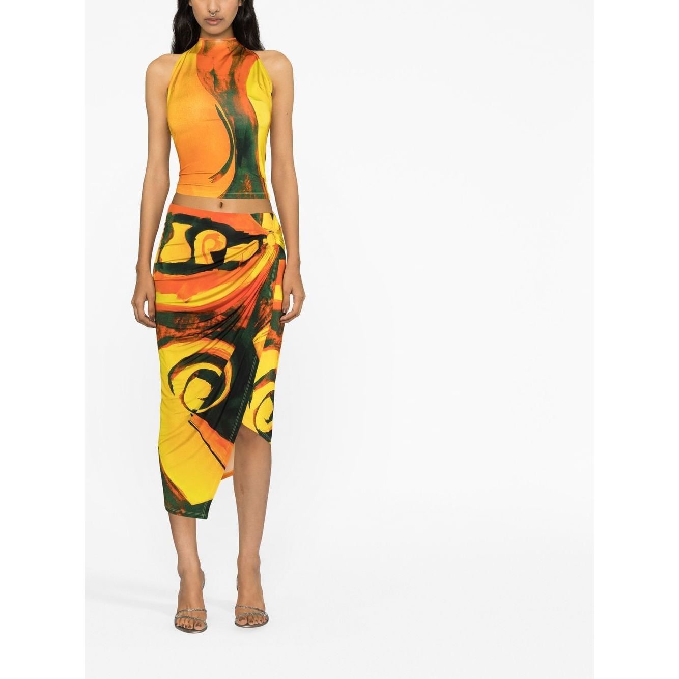 Model wearing Louisa Ballou multicolour abstract wrap skirt with high-waist and asymmetric design, featuring ring hardware detailing.