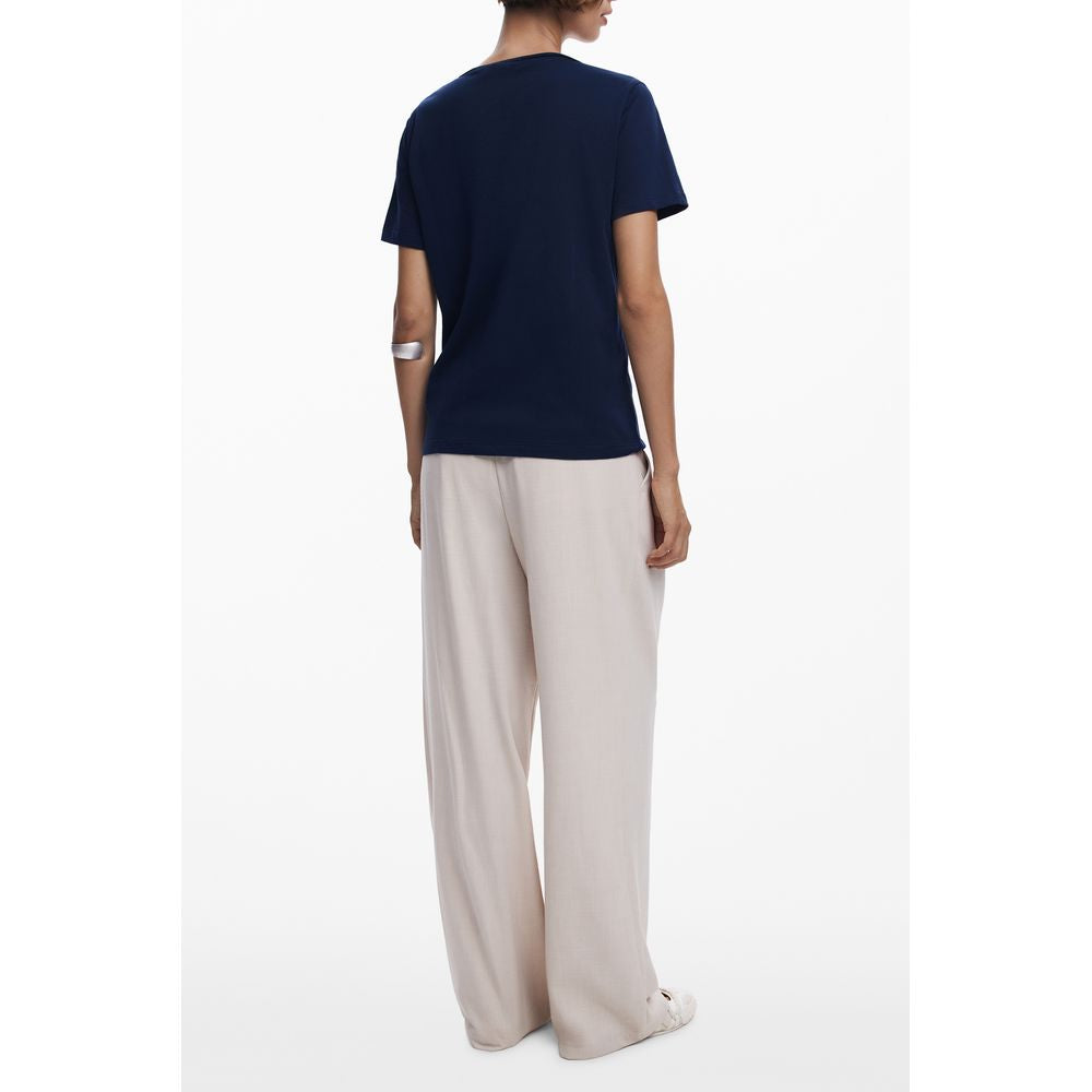 Back view of model wearing Desigual Blue Cotton Women T-Shirt, short-sleeved with V-neck and logo, styled with beige pants for a casual look.