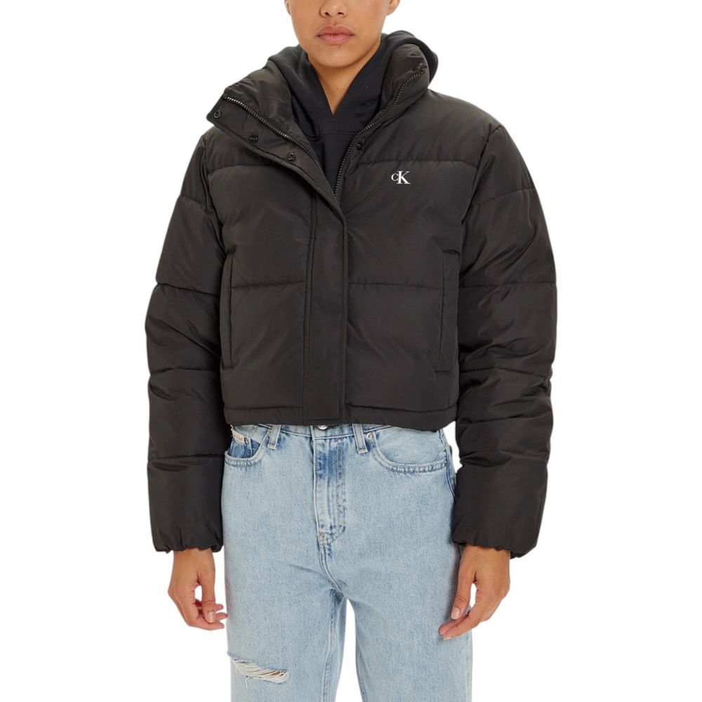 Person wearing Calvin Klein Jeans Black Polyester Jackets & Coat, cropped puffer style with high collar, showing modern silhouette.