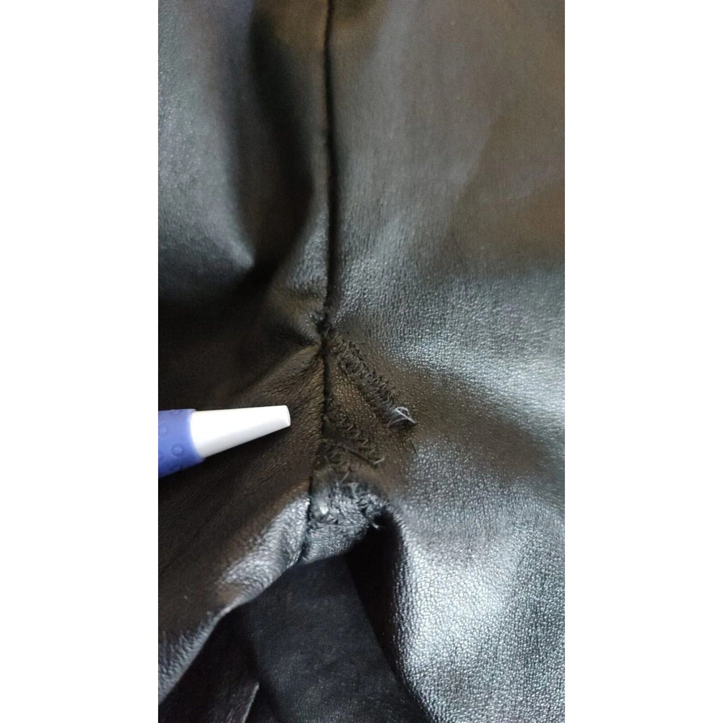 Close-up of defect repair on Dolce & Gabbana Black Leather Elastic Waist Trouser Pants.
