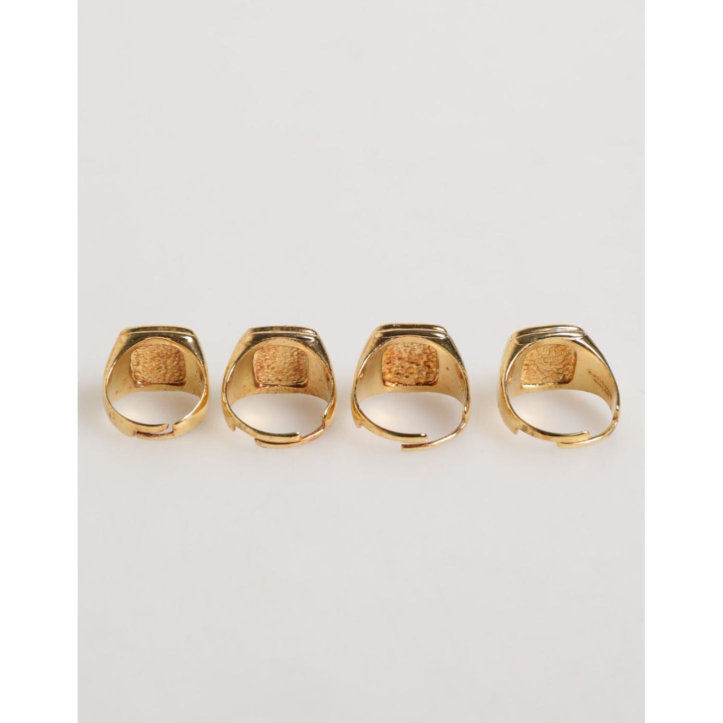 Back view of Dolce & Gabbana Gold Tone Brass JAZZ Letter Set 4 Pieces Adjustable Ring on white background.