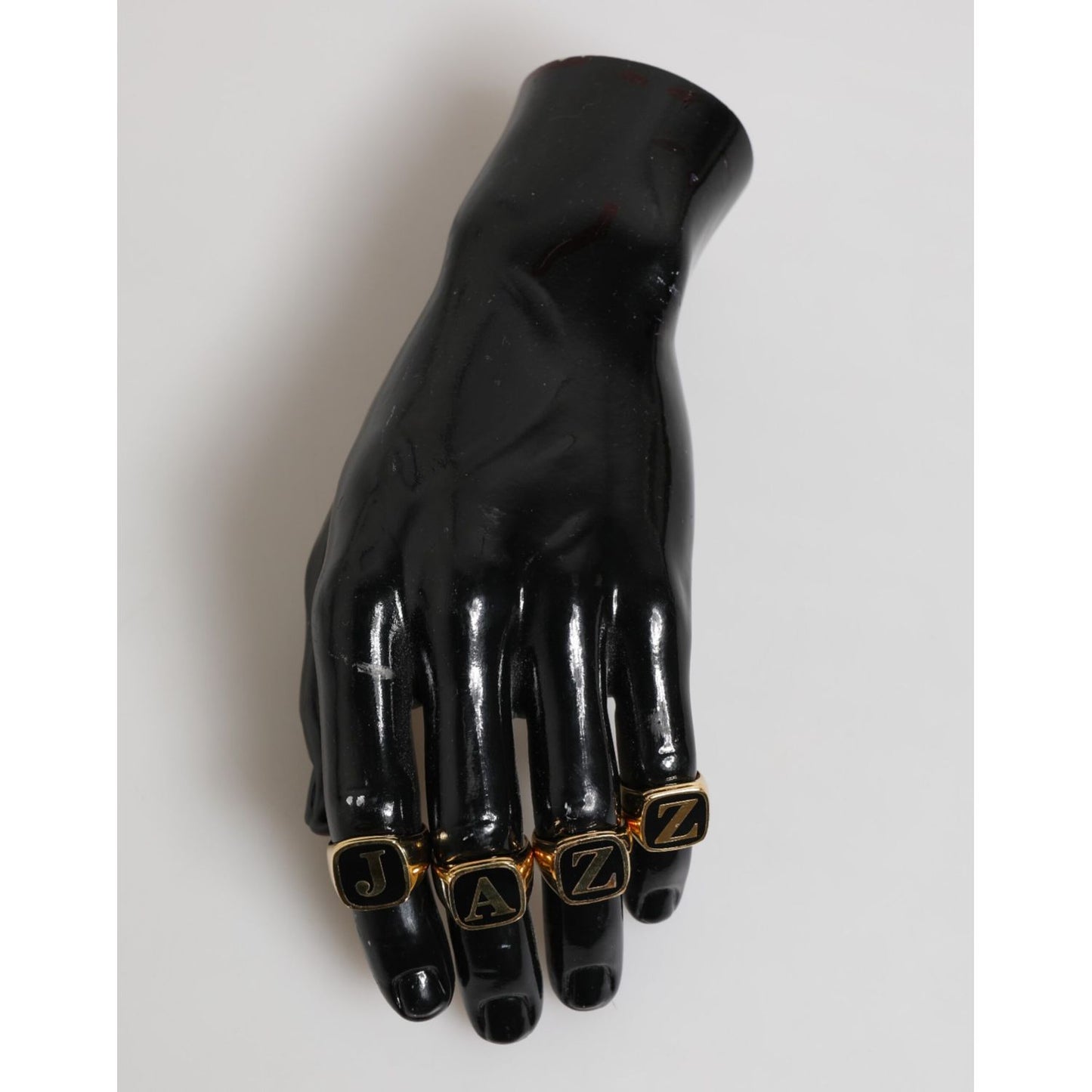Dolce & Gabbana Gold Tone Brass JAZZ Letter Set 4 Pieces Adjustable Ring displayed on black mannequin hand