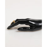 Elegantly displayed Dolce & Gabbana Gold Tone Brass Oval DG Logo Chain Adjustable Ring on black mannequin hand.