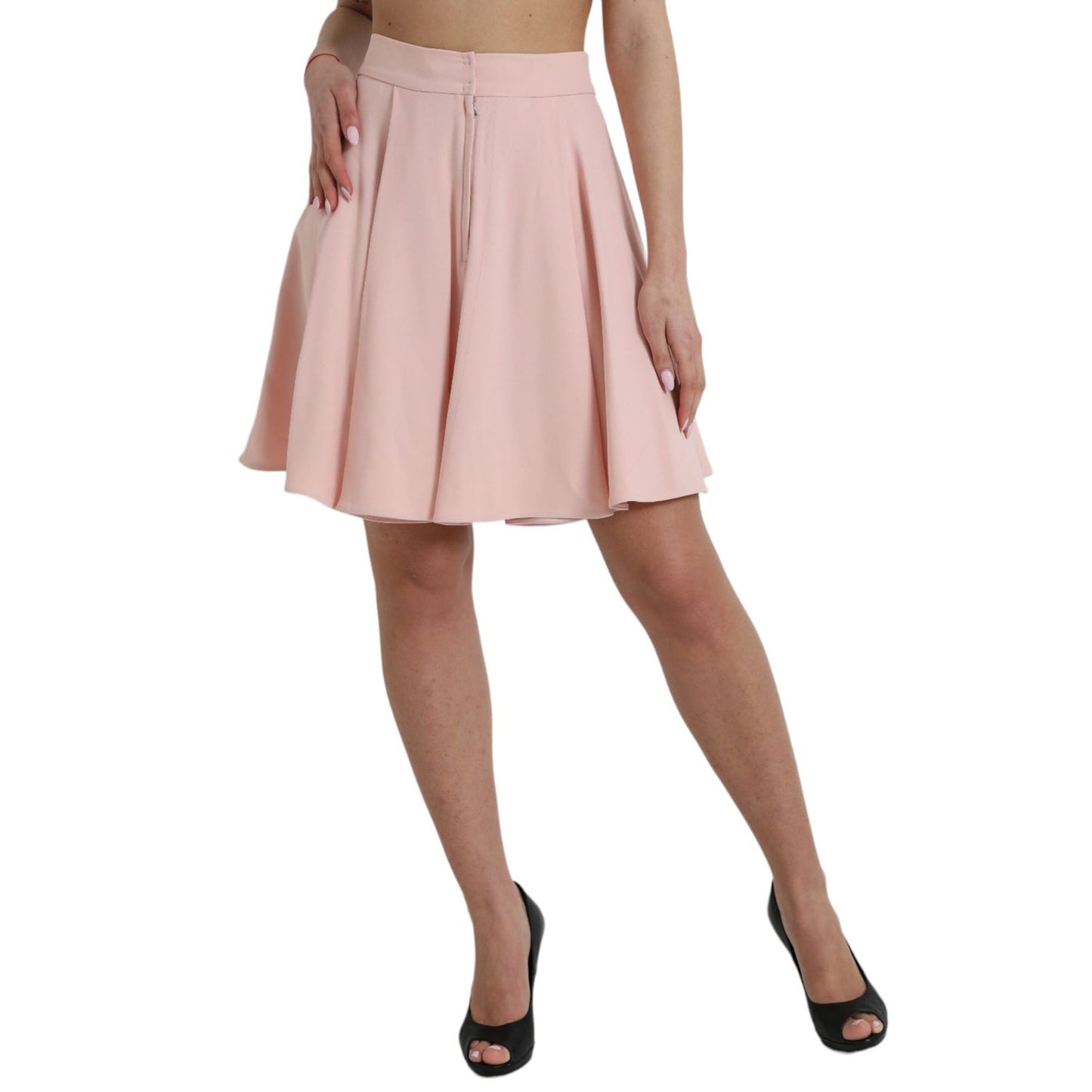 Woman wearing Dolce & Gabbana Light Powder Rose Viscose Pleated Skirt with high waist and elegant flared design.