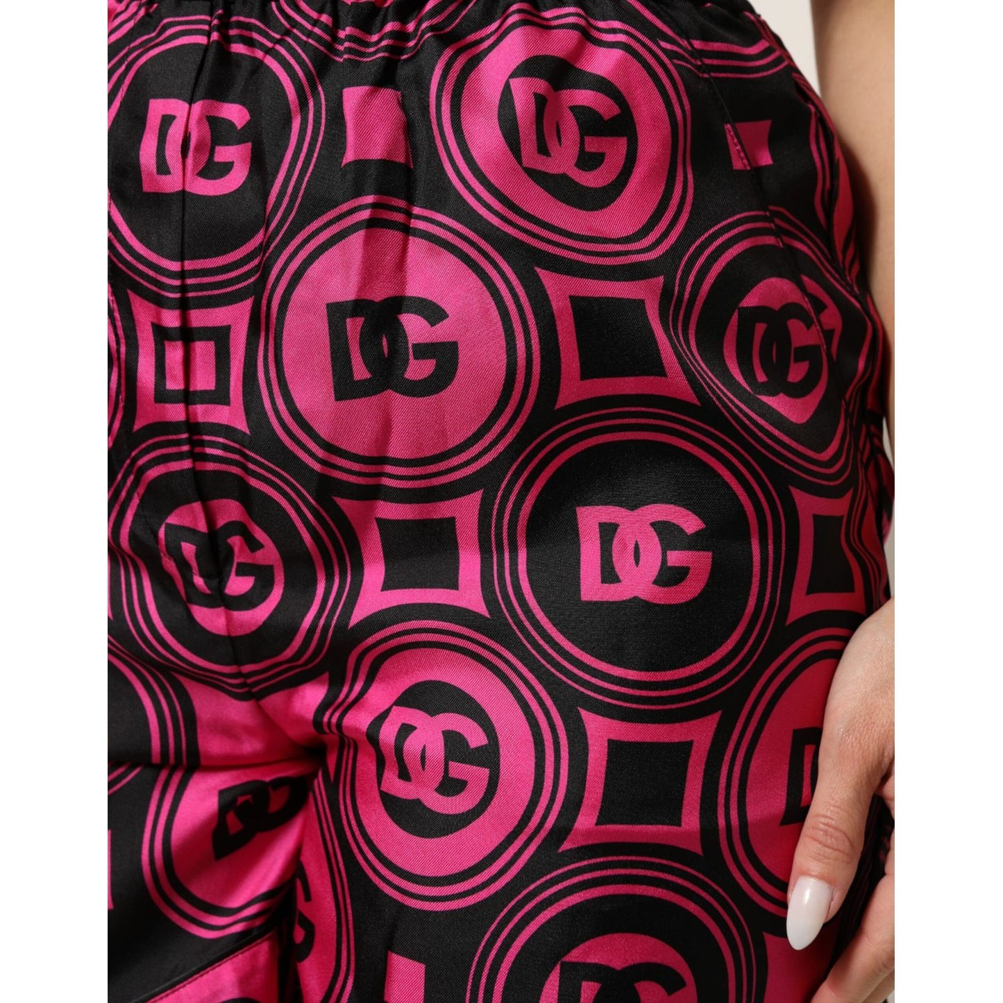 Dolce & Gabbana Pink Black Silk Logo Print DG Pattern Shorts with elastic waistband and side pocket detail in close-up view.