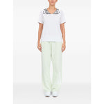 Model wearing MM6 Maison Margiela T-shirts and Polos White, showcasing front graphic print, V-neck, and short sleeves.