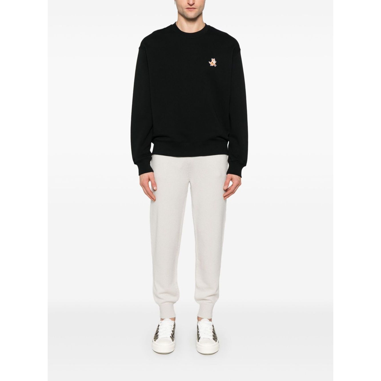 Male model wearing Maison Kitsuné Maison Kitsune speedy fox patch comfort sweatshirt in black with ribbed cuffs and hem.