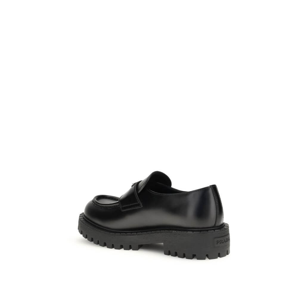 Side view of Prada Black Calf Leather Bos Taurus Slip-On Loafers with rubber sole showing craftsmanship and luxury design.