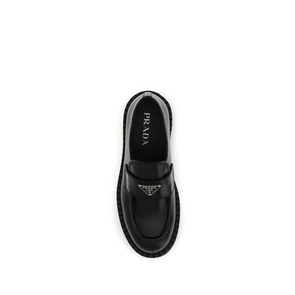 Prada Black Calf Leather Bos Taurus Slip-On Loafers with enameled triangle logo and rubber sole, top view.