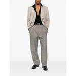 Model wearing light brown Saint Laurent trousers with front button, hook and zip fastening, and two side inset pockets, styled with a blazer.