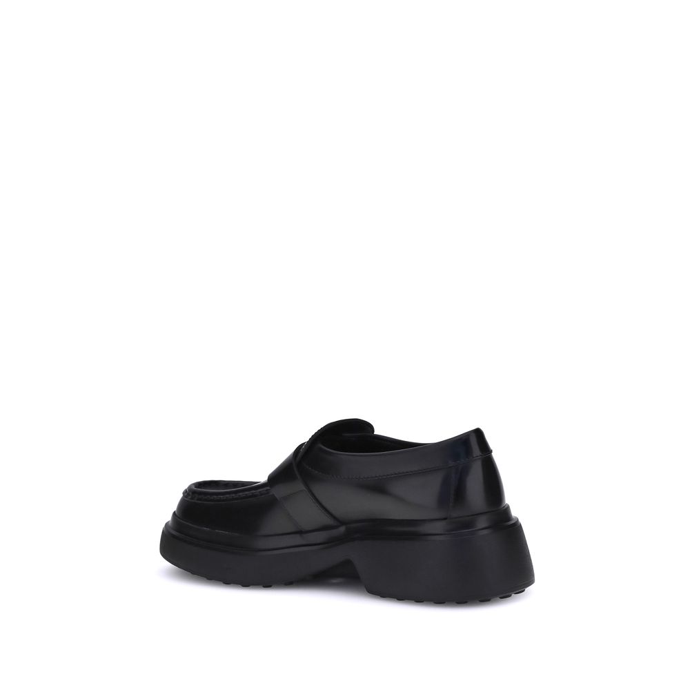 Tod's Black Rubber Platform Loafers featuring a modern platform sole with refined metal ring detail in soft nappa leather.