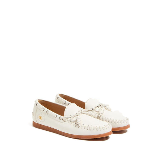 Valentino Garavani Palm Avenue Buffalo Boat Shoe in white with VLogo Signature bow and flat rubber sole.